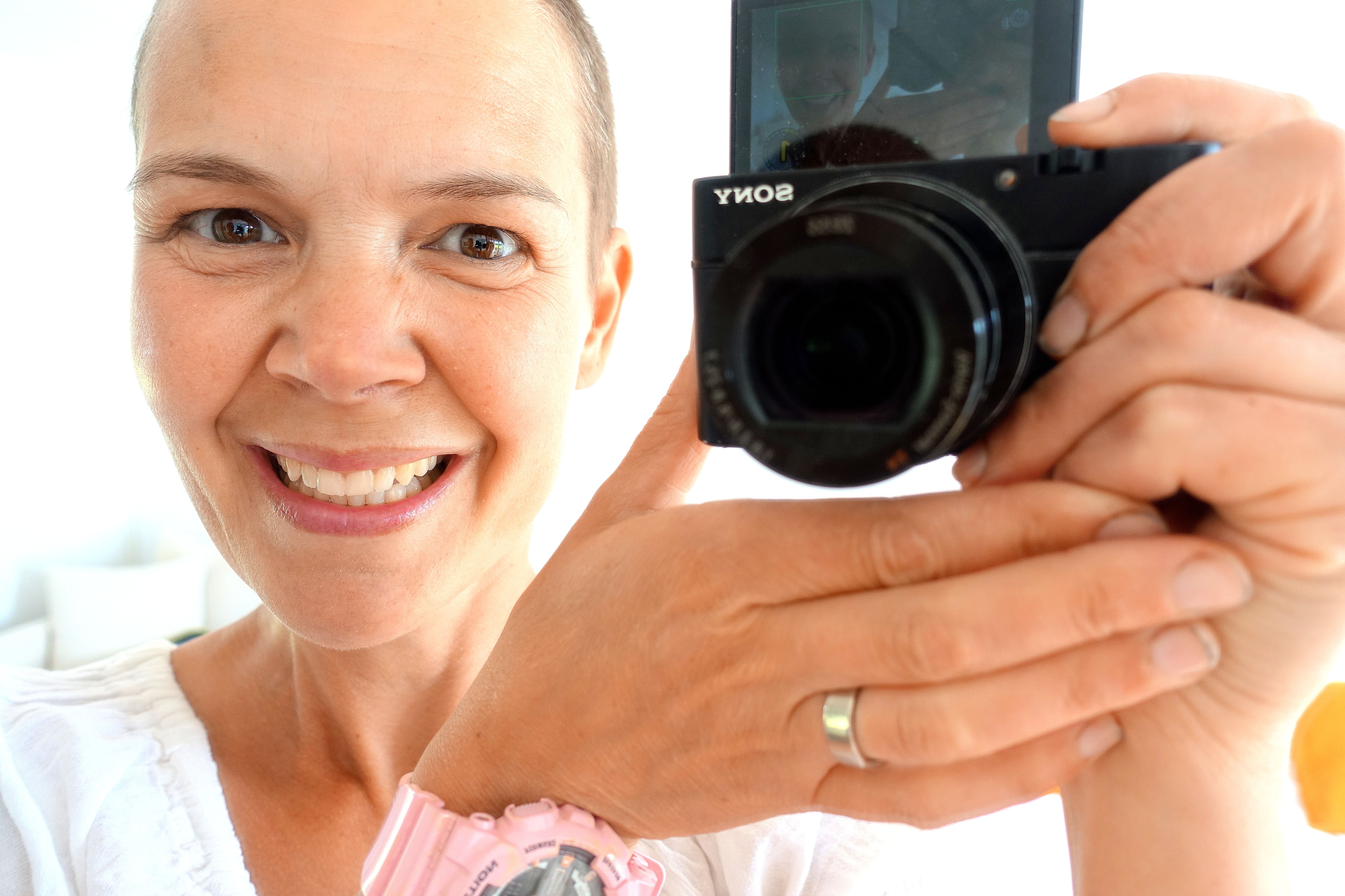 Sara tar en selfie genom en spegel, och både hon och kameran syns i bild.
