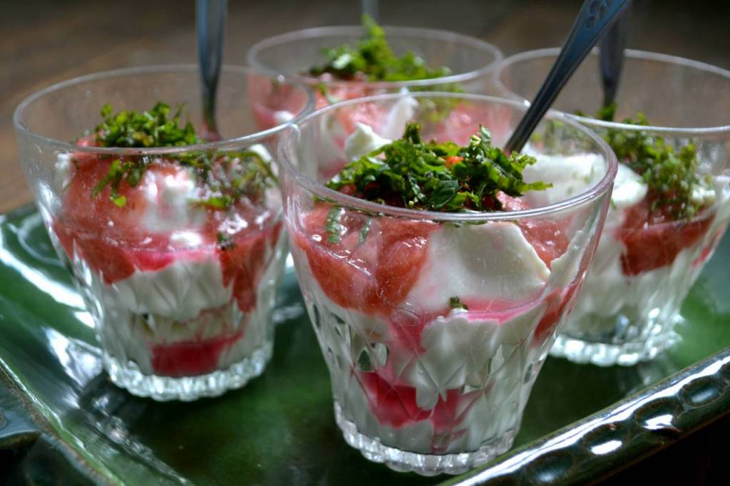 Ett fat med fyra glas yoghurt, toppad med läckert rosa rabarberkompott.