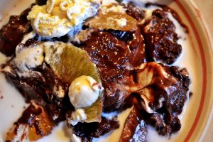 Chokladpudding med frukt, grädde och mjölk i en tallrik.