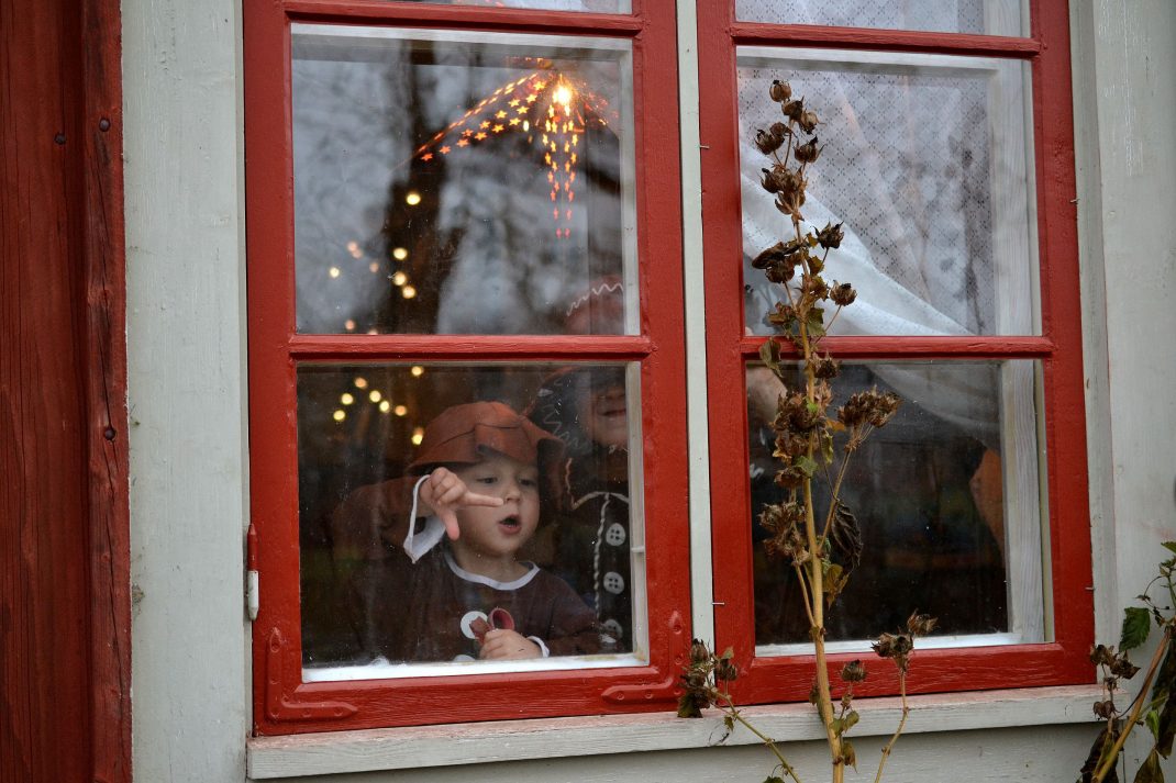 Barn i pepparkaksdräkter i ett juligt fönster. 