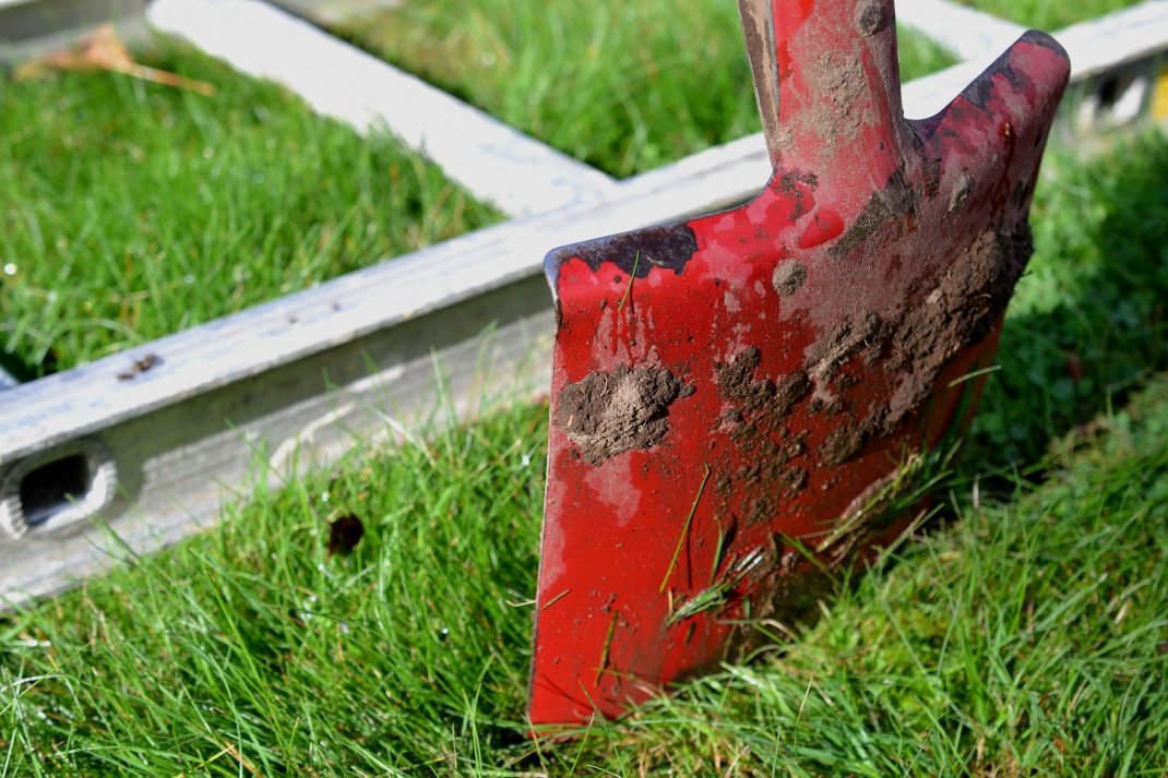 En spade gräver en linje längs en stege. No-dig gardning, a spade marking the edge of the bed.