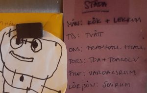 Foto av en lapp på kylskåpet med städschema.
