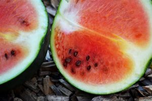 En röd vattenmelon delad i två halvor.