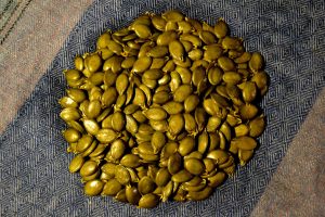 En hög med färska pumpakärnor på en kökshandduk.