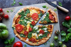 Pizza med spenat, tomat och vitlök.