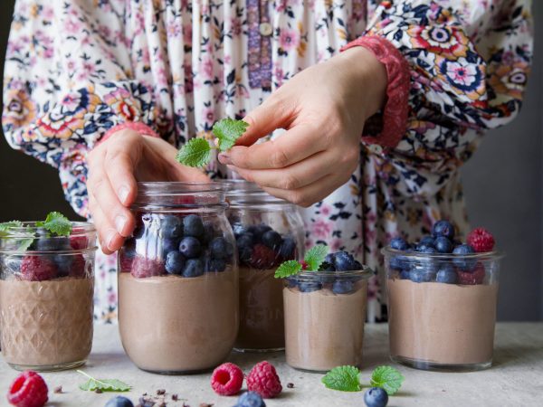 En kvinna dekorerar chokladpudding.