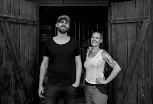 Sara Bäckmo och Johannes Wätterbäck utanför en vedbod.