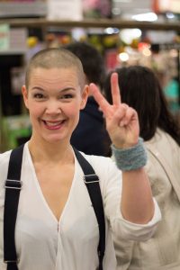 Sara gör v-tecknet i vit tröja och hängslen.