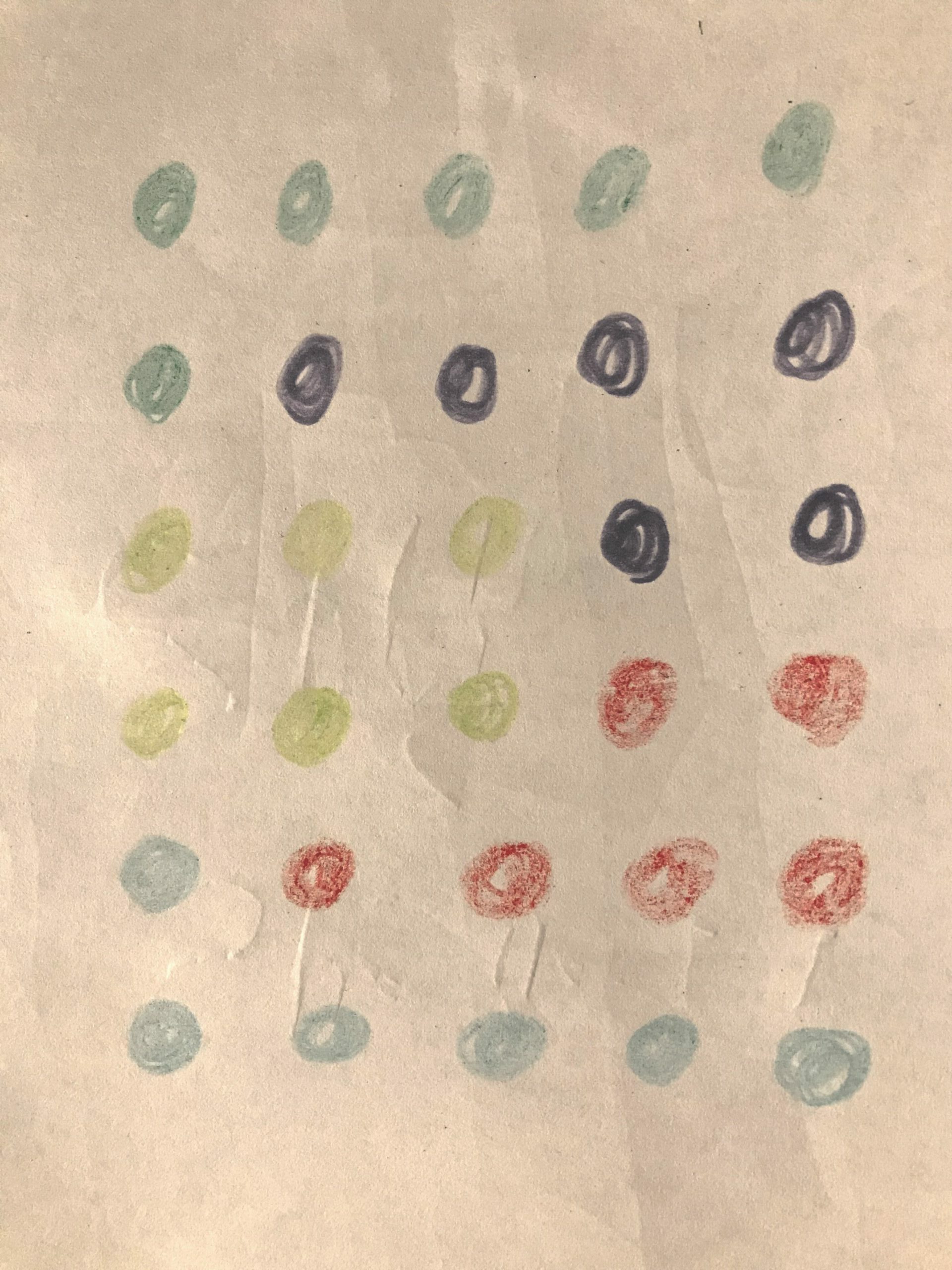 En teckning med färgade pluttar på ett papper. 