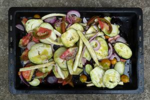 En plåt fylld med röra av aubergine, tomat och andra grönsaker.