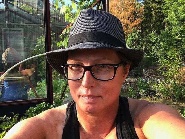 En selfie på kvinna i hatt i en trädgård. Mulching works, Anna Skog Pettersson.