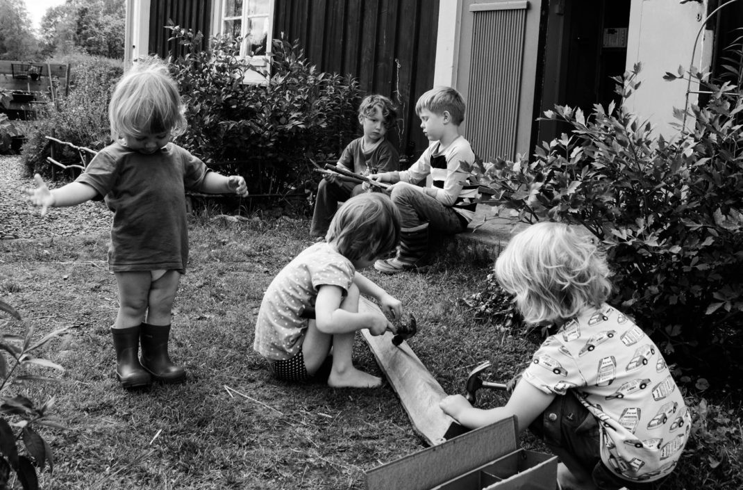 En svartvit bild av fem barn utanför huset i Skillnadens trädgård.