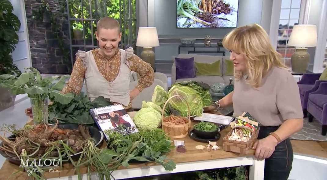 Sara och Malou står i en tv-studio med ett jättegäng grönsaker.