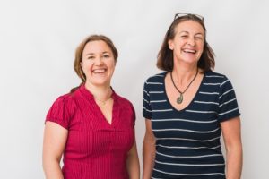Malin och Jenny tittar glada in i kameran.