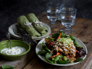En vacker dukning med tygservetter, vackra glas och en vintrig sallad med rotsaker, kyckling och bönor.