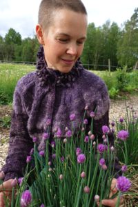 Sara sitter vid blommande gräslök.