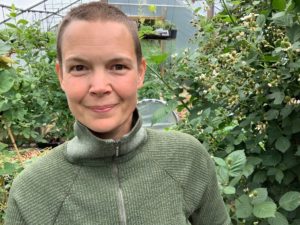 Sara i grön tröja i sitt gröna växthus.