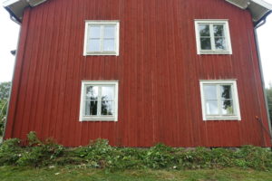En stor husgavel med en grön limpa nedanför.