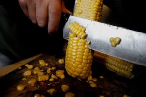 En kniv skär av korn från kolven.