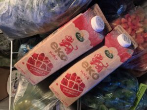Två mjölkpaket med fruset innehåll i en frysbox.