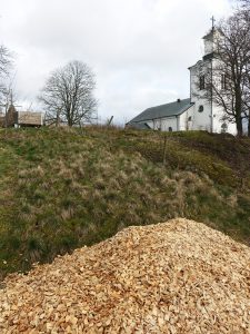 En flishög vid en grässlänt.
