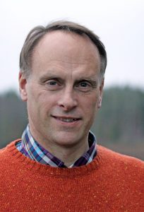 Porträttfoto på en man i orange tröja