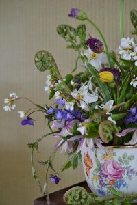 Detaljbild av en vacker bukett med sommarblommor i ett gammalt krus