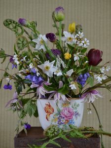 En vacker bukett med sommarblommor i ett gammalt krus