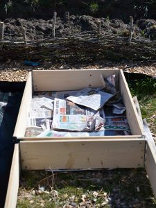 Två pallkragar varav den ena är täckt med tidningar i botten
