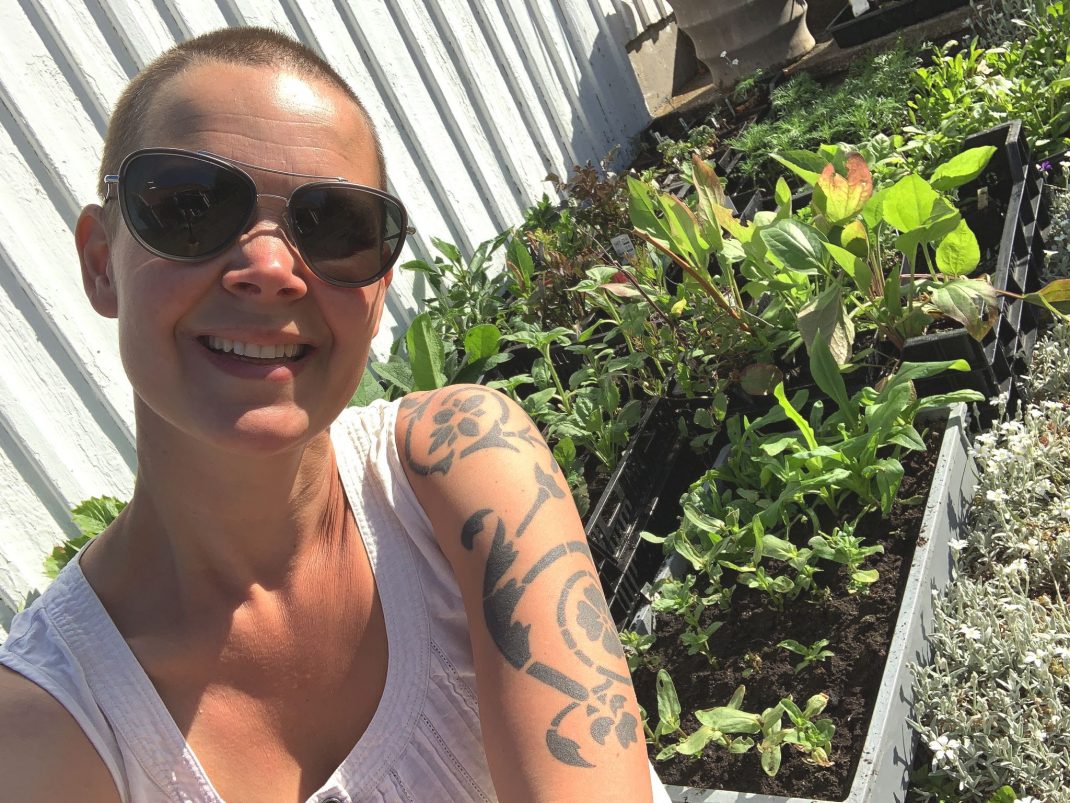 Sara sitter bredvid massor av små plantor. 