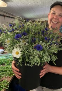 Sara håller en stor hink med buketter