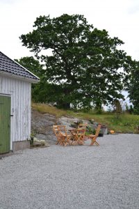 Grått grus på uteplats och träfärgade utemöbler.
