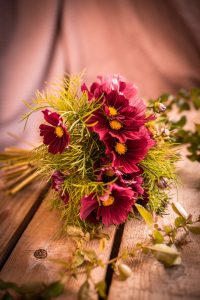 Bukett med rosa blommor och gröna blad.