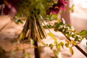 Bukett med rosa blommor och gröna blad.