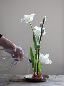 Arrangemang med blommor i en skål.