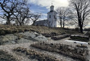 En kylig köksträdgård vid en kyrka.
