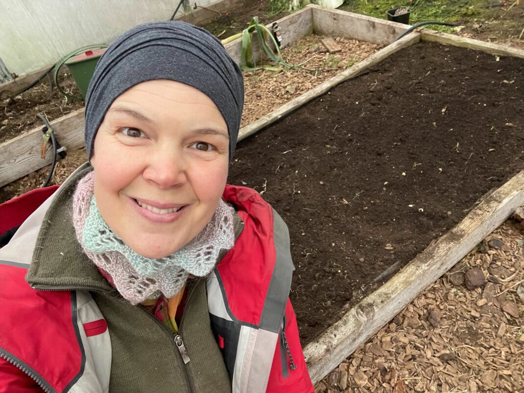 Sara vid en odlingsbädd i tunnelväxthuset.
