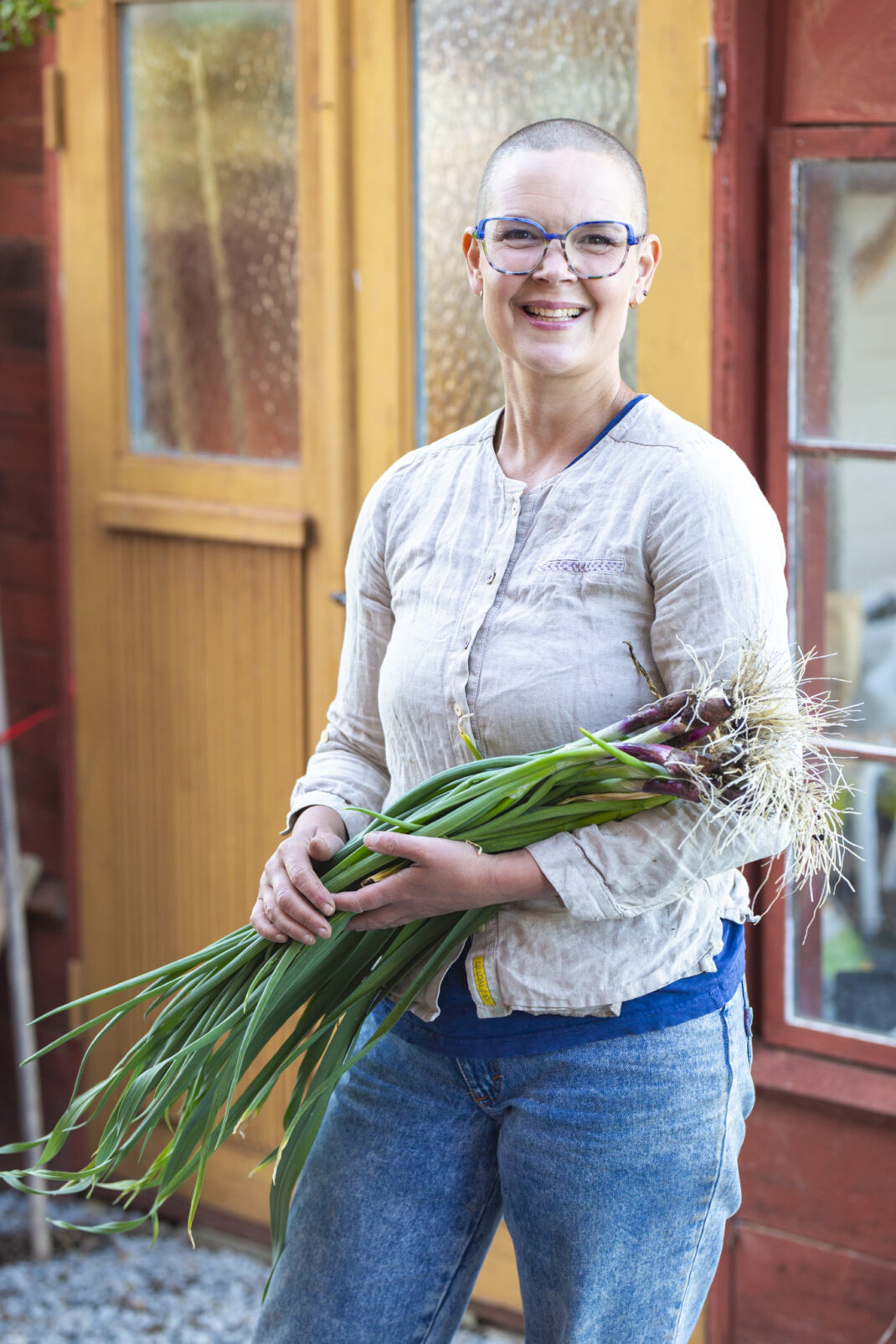 Sara med nyskördad lök från Skillnadens trädgård
