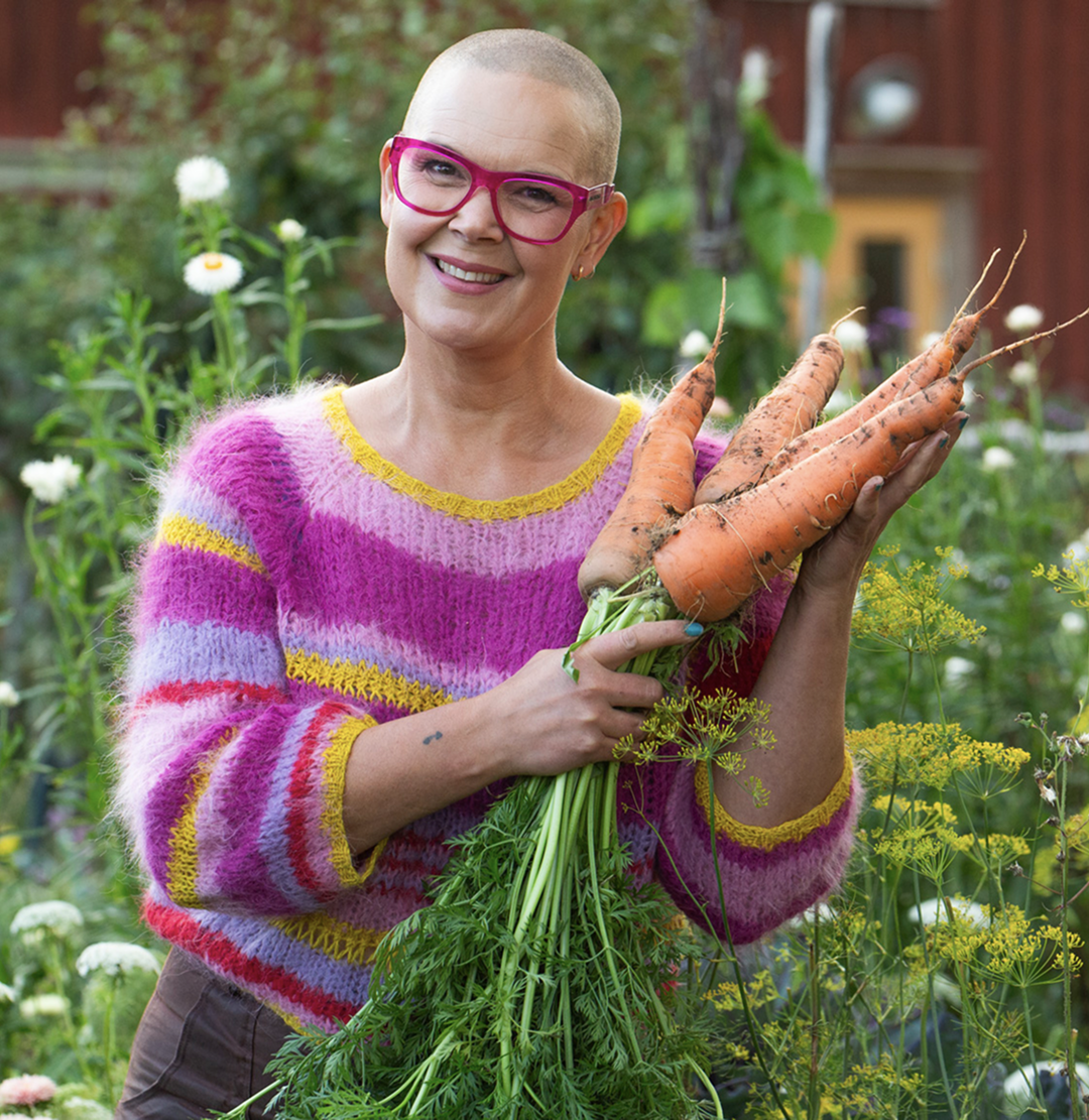 Sara Bäckmo mitt i en prunkande trädgård